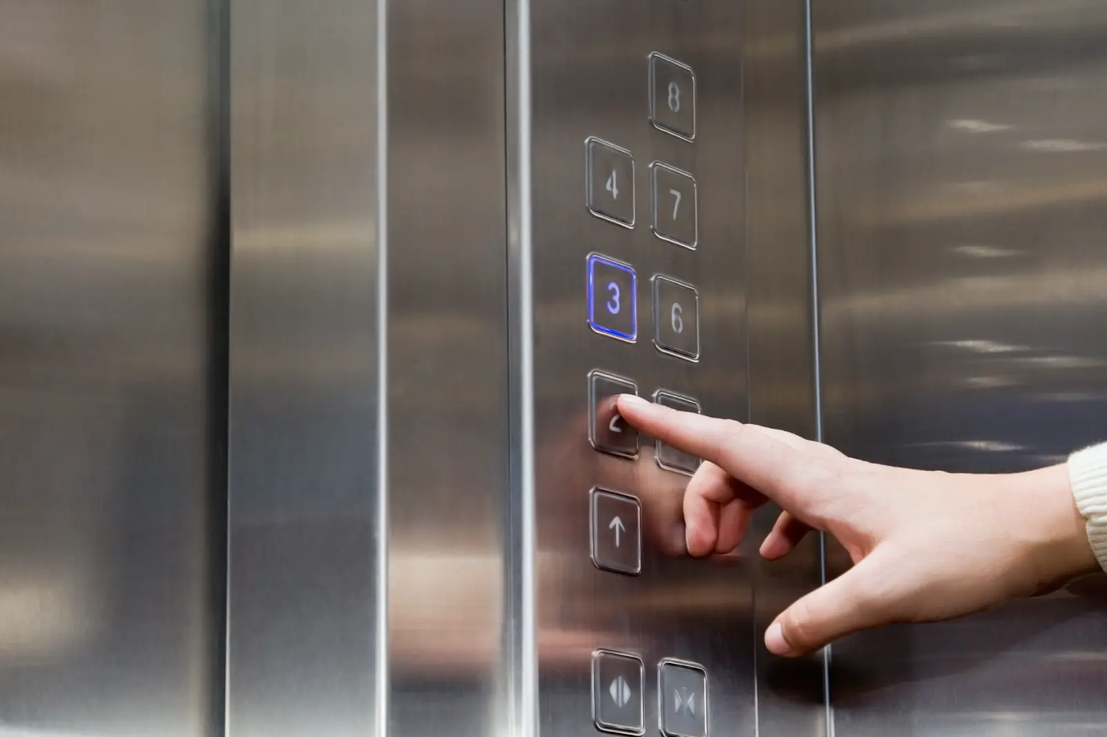 Person pressing elevator call button.